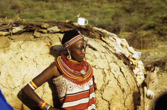 Black african girl wearing african tribal jewelry which are colorful necklaces, bracelets and earringss.
